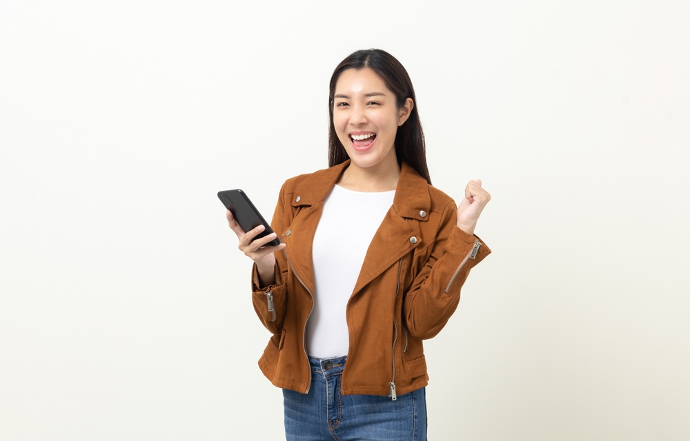 Pretty,Young,Asian,Woman,Using,Smartphone,Standing,On,Isolated,White